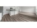 Open-concept kitchen featuring white cabinets, granite countertops, stainless steel appliances, and modern wood flooring at 1271 Pond Overlook, Nashville, NC 27856