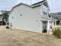 Spacious backyard view showcasing the home's siding and a cozy covered patio area with seating at 13 Knotty Pine Lane, Clayton, NC 27520