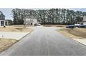 A home with well-manicured lawn and mature trees providing a serene backdrop and enhancing its curb appeal at 13 Knotty Pine Lane, Clayton, NC 27520