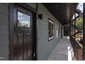 Apartment hallway with gray siding, metal railings, and a view of unit entry doors and landscaping at 1309 Hudson Ave # D16, Durham, NC 27705