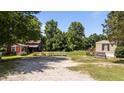 Exterior view of the property showing green grass, gravel area, and multiple buildings at 1355 Sykes Rd, Spring Hope, NC 27882