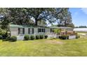 Charming home with a green metal roof, manicured landscaping, and white siding at 1355 Sykes Rd, Spring Hope, NC 27882
