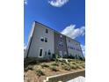 Back view of townhome, showcasing multiple windows and a tiered landscape at 1916 Fishamble St # 22, Fuquay Varina, NC 27526