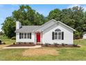Charming single-story home boasts a red front door, neat landscaping, and classic curb appeal at 1941 White Memorial Church Rd, Willow Springs, NC 27592