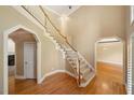 Open foyer with hardwood floors, a staircase with white railings, and arched doorways at 200 Greensview Dr, Cary, NC 27518