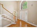 Two-story foyer features hardwood floors, a staircase, and a large arched window at 200 Greensview Dr, Cary, NC 27518