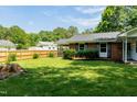 Well-maintained lawn and partial brick home exterior with black shutters offers a classic curb appeal at 2821 Regent Park Ln, Burlington, NC 27217
