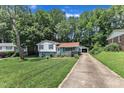 Split-level home with a long driveway leading to a detached garage, plus a spacious, well-kept lawn at 3509 Crofton Ct, Raleigh, NC 27604