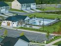 View of the community pool and clubhouse, with surrounding greenery, playground, and parking at 384 Chesapeake Commons St # 128, Garner, NC 27529