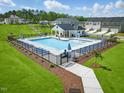 Community pool area features a fenced-in pool, lounge chairs, umbrellas and a covered pavilion at 384 Chesapeake Commons St # 128, Garner, NC 27529