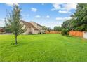 Expansive backyard with vibrant green grass and a wooden fence, offering privacy and space for outdoor enjoyment at 417 Downing Glen Dr, Morrisville, NC 27560