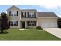 Charming two-story home featuring a well-manicured front yard and a two-car garage, creating excellent curb appeal at 417 Downing Glen Dr, Morrisville, NC 27560
