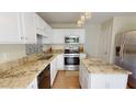 Bright kitchen with white cabinetry, stainless steel appliances, granite countertops, and a stylish backsplash at 417 Downing Glen Dr, Morrisville, NC 27560
