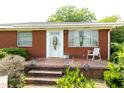 Brick front porch with a decorative front door and classic rocking chair at 728,720 S Wakefield St, Zebulon, NC 27597