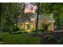Charming brick home with manicured lawn and landscape illuminated at dusk offering inviting curb appeal at 7401 Heartland Dr, Wake Forest, NC 27587
