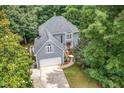 Stunning aerial view of a two-story home surrounded by lush greenery and mature trees at 7605 Sandy Lake Ct, Raleigh, NC 27613