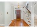 Bright foyer boasts hardwood floors, staircase, and decorative leaded glass detail on front door at 7605 Sandy Lake Ct, Raleigh, NC 27613