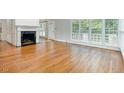 Spacious living room featuring hardwood floors, fireplace, and natural light from large windows at 7605 Sandy Lake Ct, Raleigh, NC 27613