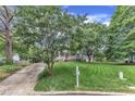 Traditional gray home with large, mature trees in the front yard has a lush lawn and landscaping at 8121 Bentwood Pl, Raleigh, NC 27615