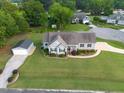 An aerial view of the property showcasing its well-maintained landscaping, detached garage, and inviting curb appeal at 817 Mossy Oak Dr, Fuquay Varina, NC 27526
