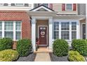 Inviting front door with decorative wreath, enhanced by lush landscaping and charming architectural details at 886 Cupola Dr, Raleigh, NC 27603