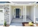 Inviting front porch with stone accents, a stylish black door, and classic white support columns at 96 Northwood Dr, Fuquay Varina, NC 27526