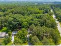 Sprawling treeline with a home nestled within, featuring a long driveway and adjacent road at 104 Woodcrest Dr, Chapel Hill, NC 27516