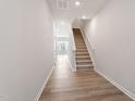 The bright entryway of this home features hardwood floors, leading up to the second story staircase at 123 Central Townes Way # 302, Raleigh, NC 27603