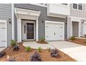 Inviting entrance featuring a dark front door, attached garage, and nicely landscaped yard at 131 Central Townes Way # 304, Raleigh, NC 27603
