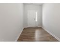 Clean entryway with wood-look floors and a white front door with glass panels at 131 Central Townes Way # 304, Raleigh, NC 27603