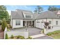 A beautiful white brick home with a gray roof, two-car garage, and landscaped front yard at 1312 Duplin Rd, Raleigh, NC 27607