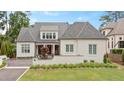 Beautifully landscaped white brick home boasts lush lawn and manicured landscaping at 1312 Duplin Rd, Raleigh, NC 27607