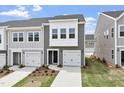 New two-story townhouse showcasing a white garage door, black front door, and landscaped front yard at 139 Central Townes Way # 306, Raleigh, NC 27603