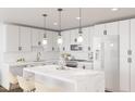 Bright kitchen features white cabinets, marble countertops, a stylish island, and pendant lighting at 140 Two Hills Dr # 302C, Carrboro, NC 27510