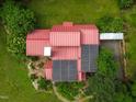 Aerial view of a red roof with solar panels set amongst lush greenery at 145 Ryan Rd, Pittsboro, NC 27312
