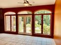 Bright sunroom featuring arched windows offering scenic garden views and tile flooring at 145 Ryan Rd, Pittsboro, NC 27312