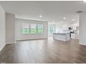 Open-concept living room and kitchen featuring hardwood floors, recessed lighting, and a bright, airy feel at 190 Babbling Creek Dr, Youngsville, NC 27596