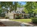 Lovely home featuring a spacious three-car garage, a covered front porch, manicured lawn, and beautiful landscaping at 2328 Forestbluff Dr, Fuquay Varina, NC 27526