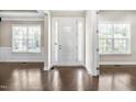 Bright foyer with polished hardwood floors, a white front door, and ample natural light at 2527 Sidewinder Ct, Apex, NC 27523