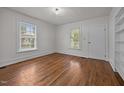 Cozy bedroom featuring hardwood floors, white walls, and ample natural light from the large windows at 303 N Watauga Ave, Dunn, NC 28334