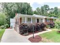 Beautiful home with white siding, brick details, covered porch, and lush landscaping at 325 Northfield Dr, Raleigh, NC 27609
