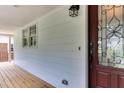 Close-up of front porch with wood flooring, modern lighting, and decorative glass door at 325 Northfield Dr, Raleigh, NC 27609