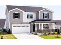 Inviting two-story home with gray siding, black shutters, a two-car garage, and a well-manicured front lawn at 361 Providence Creek Dr, Fuquay Varina, NC 27526