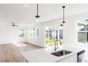 Bright kitchen with stainless steel appliances, an island sink, and views of the living area and backyard at 361 Providence Creek Dr, Fuquay Varina, NC 27526