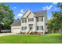 Lovely two-story home featuring blue shutters, an attached garage, well-kept lawn, and manicured landscaping at 3713 Highland Creek Dr, Apex, NC 27539