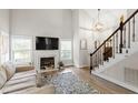 Bright living room showcasing a fireplace, staircase, high ceiling and an open layout at 425 Hidden Cellars Dr, Holly Springs, NC 27540