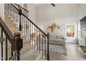 View from stairs into a living room with a fireplace, bright windows, and stylish decor at 425 Hidden Cellars Dr, Holly Springs, NC 27540