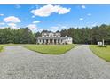 A two-story white home featuring a charming wrap-around porch and a circular driveway at 4737 Uzzle Rd, Rougemont, NC 27572