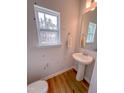 Powder room with a pedestal sink, wood-look flooring, window, and modern fixtures at 523 Beacon Hill Rd # 31, Lillington, NC 27546