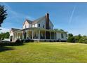 Expansive property featuring a well-maintained home with a long, inviting porch and lush green lawn at 526 Bob Rainey Trl, Burlington, NC 27217
